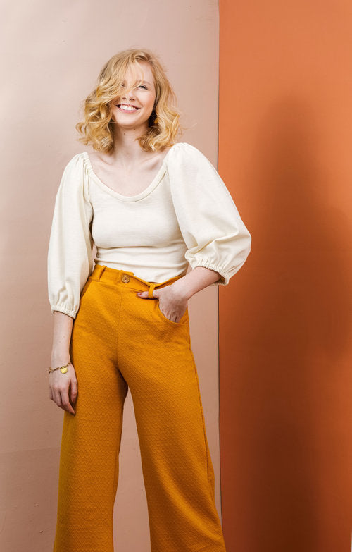 Woman wearing the Adrienne Blouse sewing pattern by Friday Pattern Company. A blouse pattern made in knits or jersey fabric featuring billowy statement sleeves that are gathered up at the shoulders and a medium low round neckline.