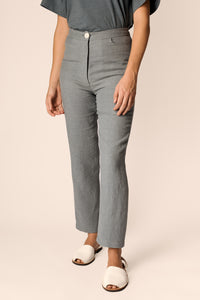Woman wearing the Aina Trousers sewing pattern from Named on The Fold Line. A trouser pattern made in linen, hemp, cotton or light denim fabrics, featuring a semi-fit, high rise, fly zipper closure, front pockets, patch back pockets, waistband with side b