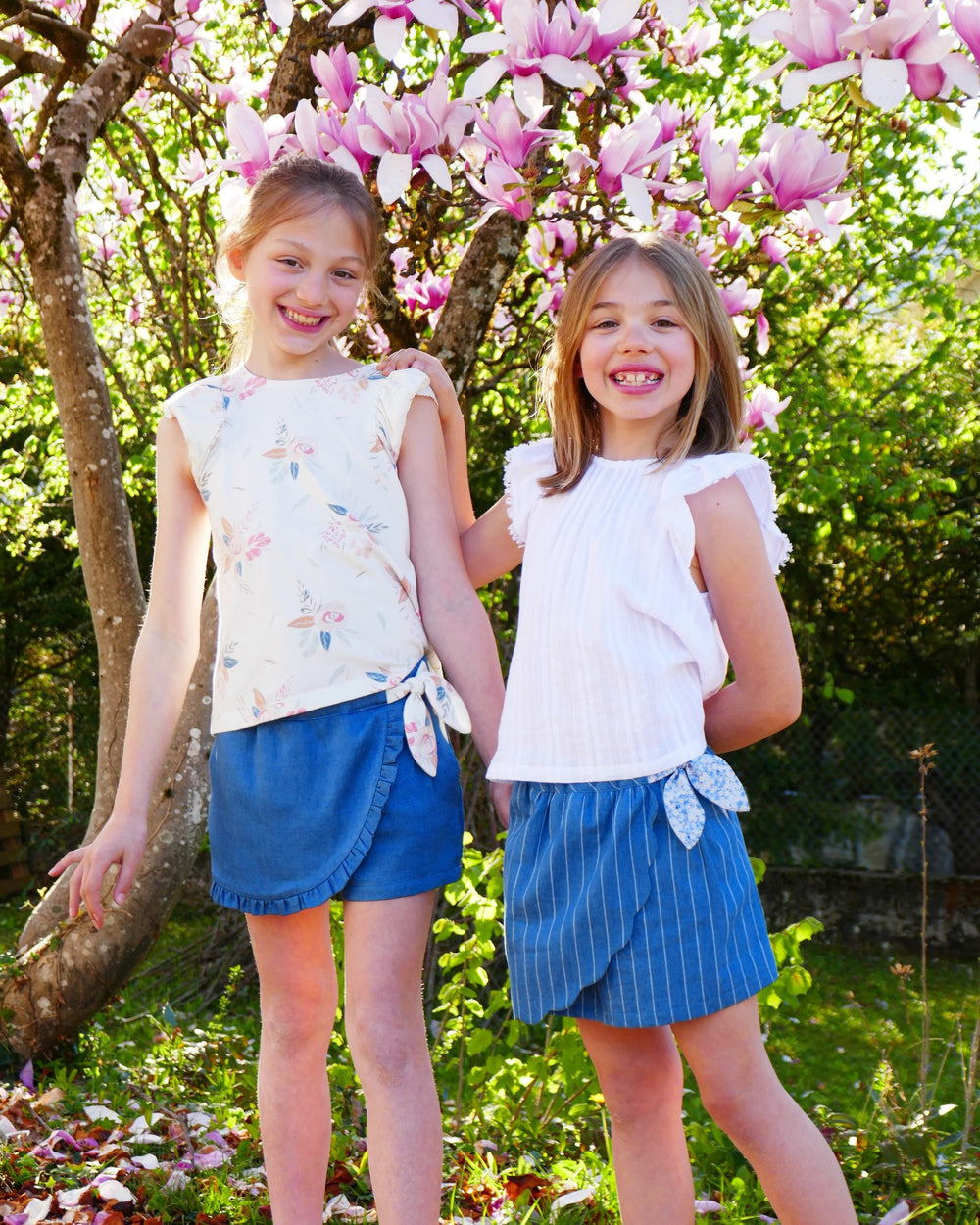 Children wearing the Child/Teen Aconit Skort and Skirt sewing pattern from Petits D'om on The Fold Line. A skort and skirt pattern made in chambray, Tencel, poplin, linen, viscose, denim or seersucker fabrics, featuring a mid-thigh length, added front pan
