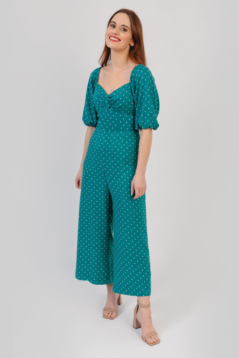 Woman wearing the Adele Jumpsuit sewing pattern from Sew Love Patterns on The Fold Line. A jumpsuit pattern made in viscose, tencel, crepe, velvet, satin rayon and cotton fabrics, featuring a cropped length, short puff sleeves with gathered elastic at the