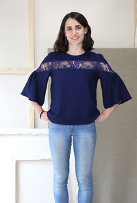 Woman wearing the Afternoon Tea Blouse sewing pattern from Liesl + Co on The Fold Line. A blouse pattern made in crepe, rayon challis, charmeuse, georgette, lawn, and linen fabrics, featuring a semi-fit, round neck, inset bodice panel in contrasting fabri
