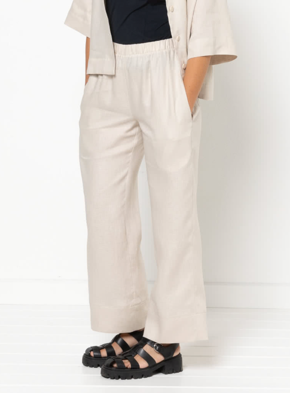 Woman wearing the Albie Woven Pant sewing pattern from Style Arc on The Fold Line. A pants pattern made in linen, silk, rayon, or crepe fabric, featuring an elastic waist (sits at the natural waist), straight leg, in-seam pockets, and back patch pockets.