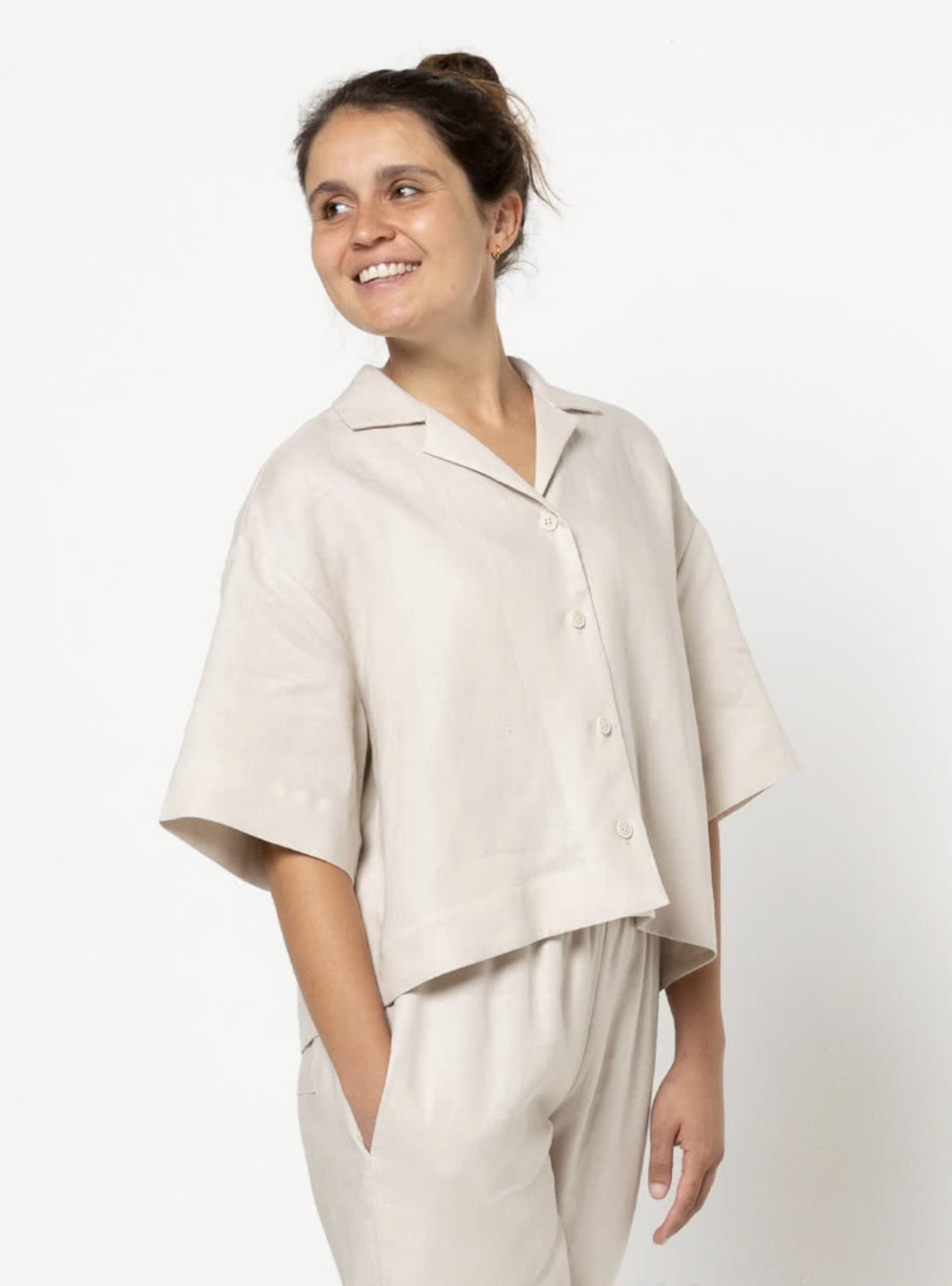 Woman wearing the Albie Woven Shirt sewing pattern from Style Arc on The Fold Line. A shirt pattern made in linen, cotton, silk, or any suitable shirting fabric, featuring a boxy fit, button front, extended shoulder line, back yoke with pleats, dropped ar