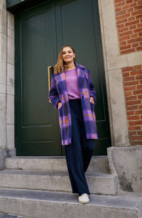 Woman wearing the Alex Coat sewing pattern from Atelier Jupe on The Fold Line. A Coat pattern made in wool, wool-blend, polyester, jacquard or heavy corduroy fabrics, featuring a mid-length, large collar and lapels, front pockets, back vent and single fro