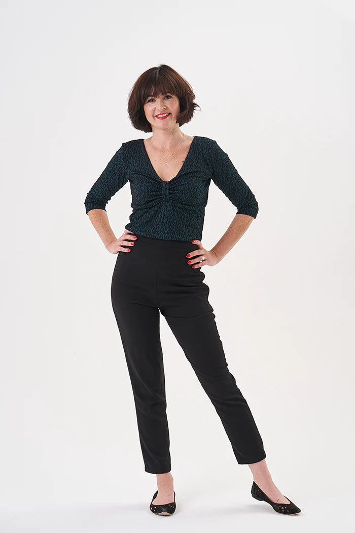 Woman wearing the Alice Top sewing pattern from Sew Over It on The Fold Line. A top pattern made in viscose jersey, cotton jersey, silk jersey, or a lightweight rib knit fabric, featuring a slim fit, v-neck, bow-effect bust detail, and 3/4 length sleeves.