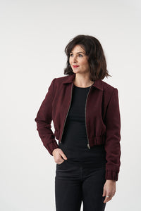 Woman wearing the Amelia Jacket sewing pattern from Sew Over It on The Fold Line. A jacket pattern made in cotton twill, corduroy, boucle, twill crepe, or wool fabric, featuring bust darts, a zipped front, flat collar, long set-in sleeves with elasticated