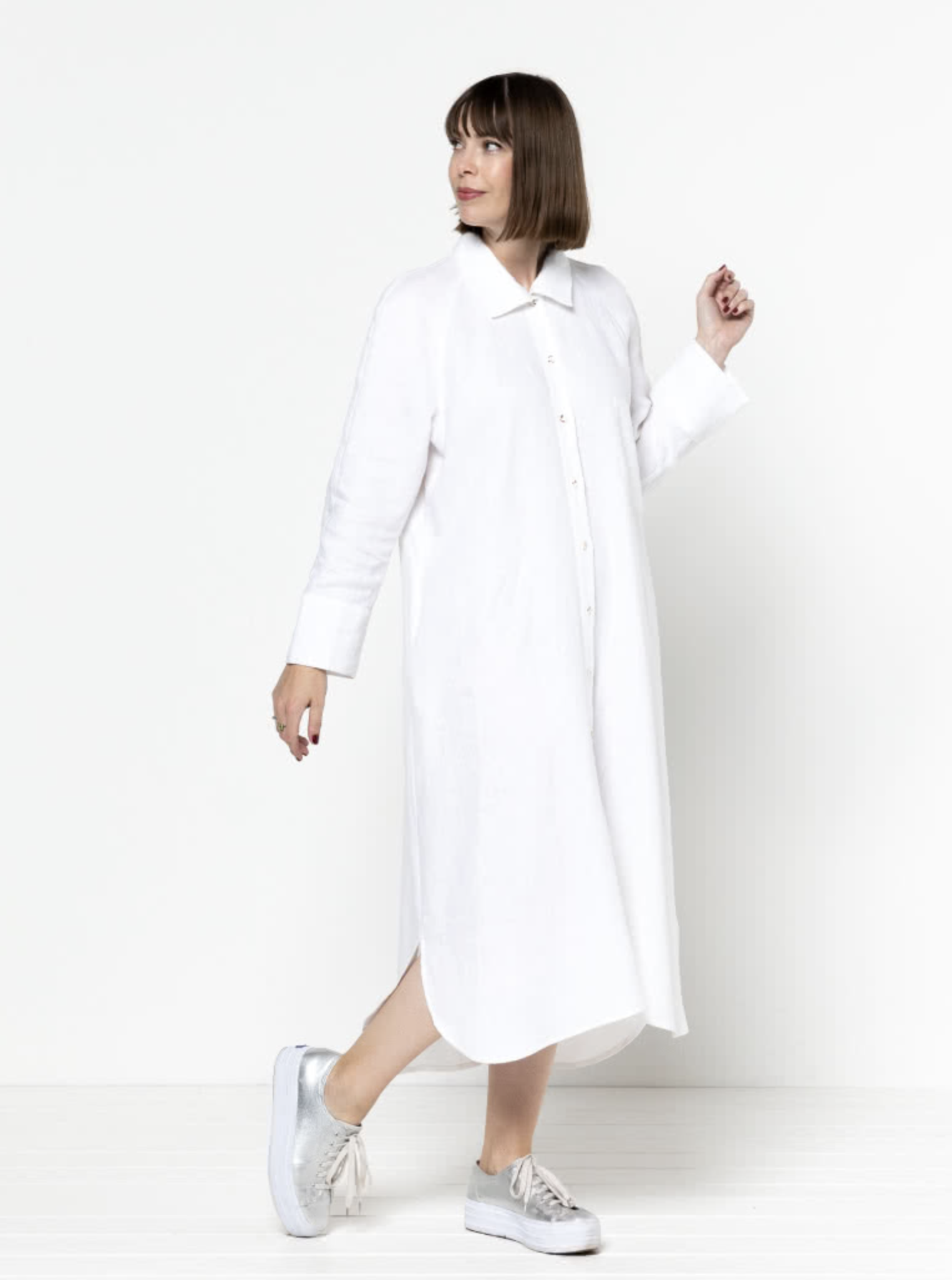 Woman wearing the Anais Woven Dress sewing pattern from Style Arc on The Fold Line. A shirt dress pattern made in washed linen, rayon, crepe or silk fabrics, featuring a relaxed fit, button front closure, one-piece collar, long raglan sleeves with fold-ba