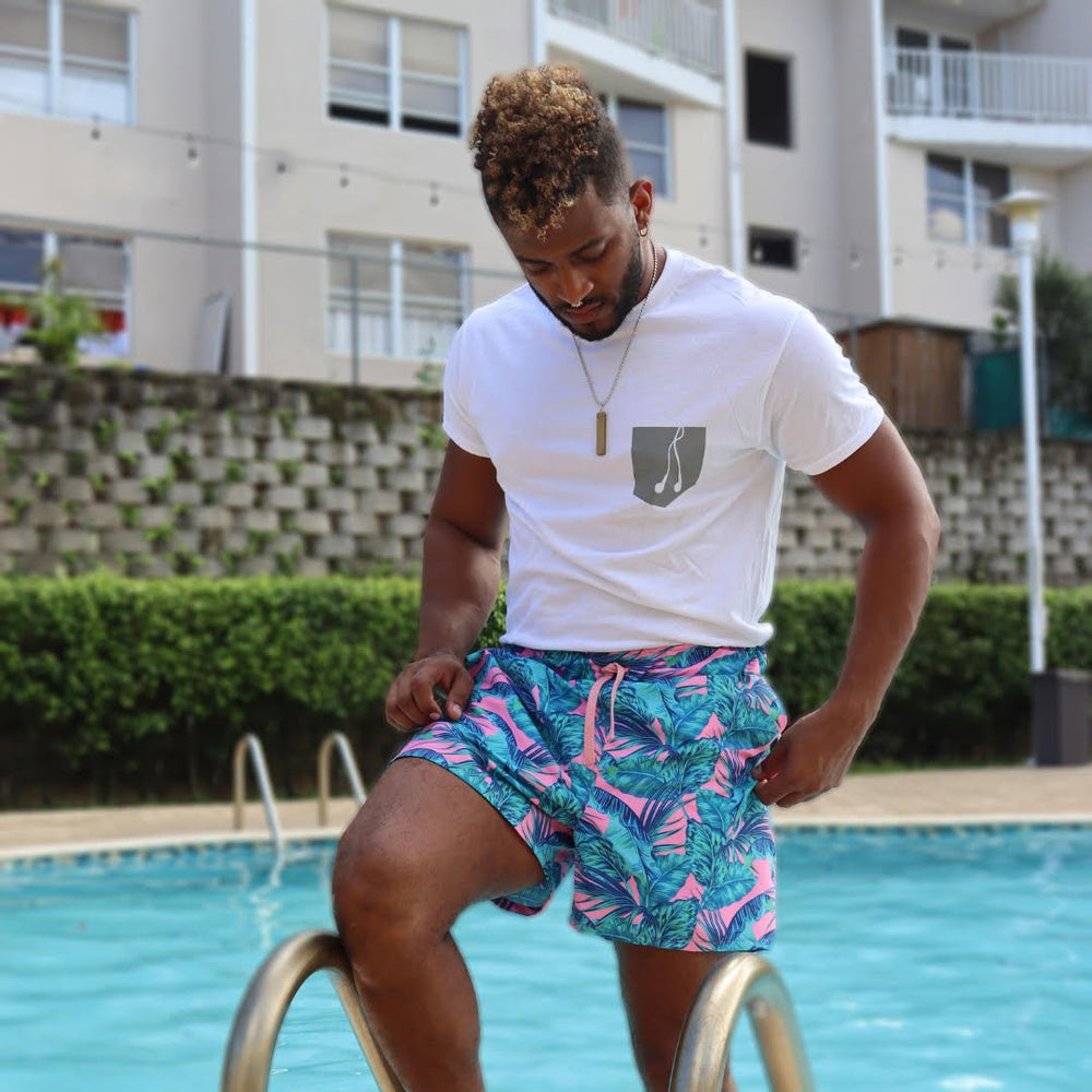 Man wearing the Andrew Swimsuit sewing pattern from Sirena Patterns on The Fold Line. A swim shorts pattern made in nylon or polyester fabrics, featuring an elastic and drawstring waist, side seam pockets, attached inner brief, inseam and back flap pocket