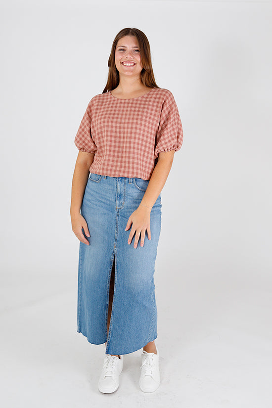 Woman wearing the Aria Top sewing pattern from Chalk and Notch on The Fold Line. A top pattern made in challis, chambray, double gauze, lawn, linen, voile fabrics, featuring a bubble-shape, elasticated elbow-length sleeves, round neck, and cropped length.