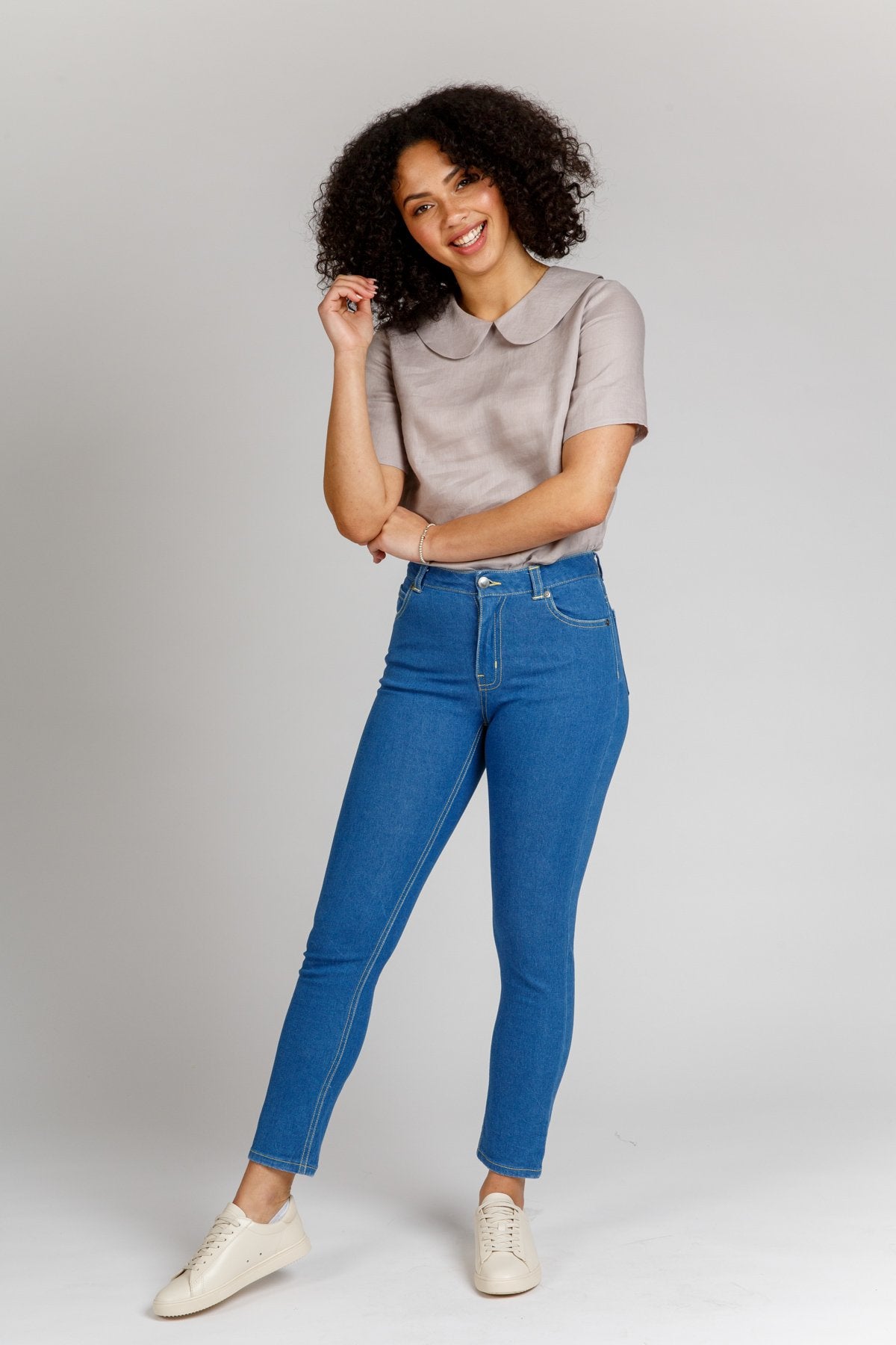 Woman wearing the Ash Jeans sewing pattern from Megan Nielsen on The Fold Line. A jeans pattern made in stretch denim fabrics, featuring a slim leg, ankle length, fly zip, waistband with button closure, front pockets, coin pocket, back patch pockets, belt