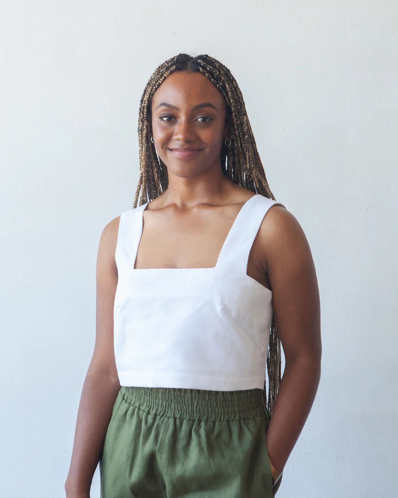 Woman wearing the Aster Top sewing pattern from True Bias on The Fold Line. A top pattern made in cotton, linen or rayon fabrics, featuring a square front and back neckline, squared off armholes, angled French darts, button-back opening, and cropped lengt