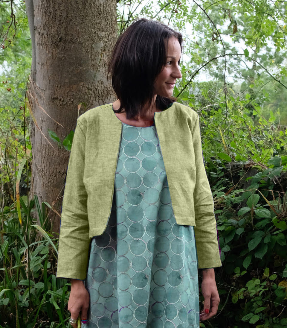 Woman wearing the Aurora Jacket sewing pattern from Sew Different on The Fold Line. A jacket pattern made in cotton, linen, raw silk, denim, denim or velvet fabrics, featuring a boxy silhouette, round neckline, bust darts, slanted lower hemline that drops