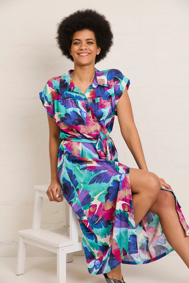 Woman wearing the Ava Summer Dress sewing pattern from Atelier Jupe on The Fold Line. A dress pattern made in viscose, cotton, tencel, double gauze, or linen fabric, featuring a button placket, collar with stand, bodice gathers, folded cuffs, a belt, and 