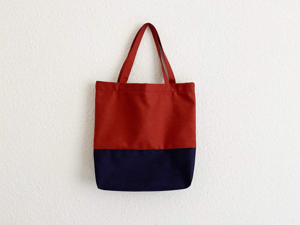 Picture showing the Ava Tote Bag sewing pattern from Tammy Handmade on The Fold Line. A tote bag pattern made in canvas, linen or upholstery weight fabrics, featuring a colour blocking effect and looped handles.