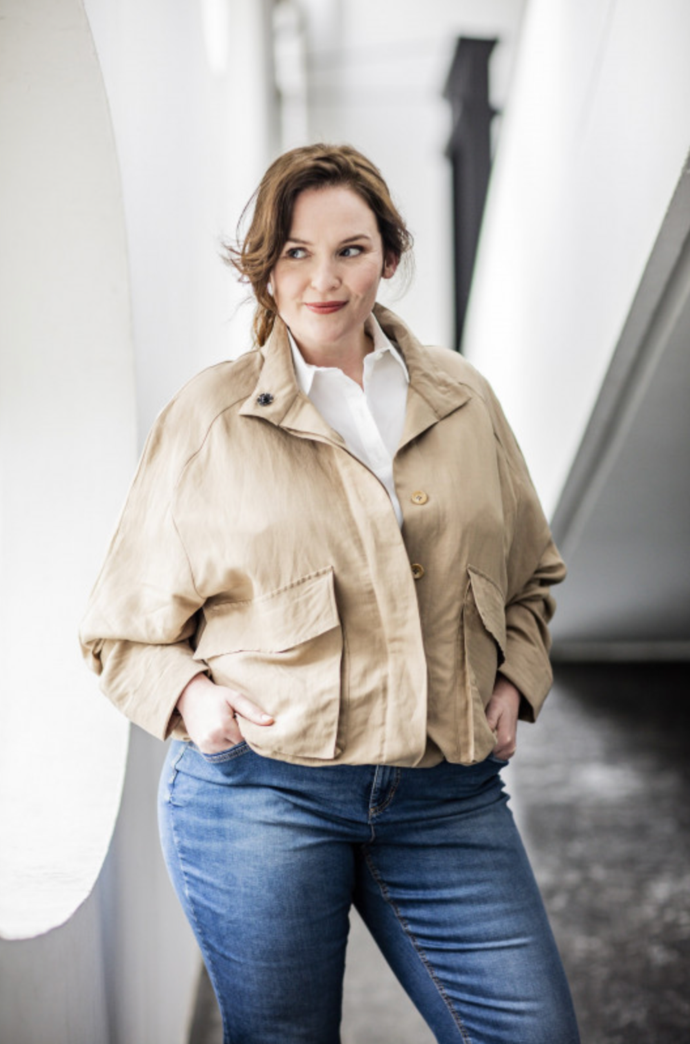 Woman wearing the Avril Jacket sewing pattern from Fibre Mood on The Fold Line. A Jacket pattern made in cotton twill, linen, crepe or jacquard fabrics, featuring a cropped length, stand collar, hidden button placket and gusseted patch pockets with button