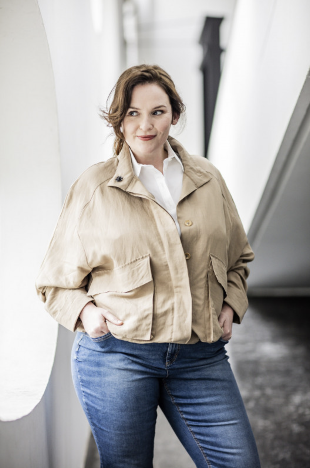 Woman wearing the Avril Jacket sewing pattern from Fibre Mood on The Fold Line. A Jacket pattern made in cotton twill, linen, crepe or jacquard fabrics, featuring a cropped length, stand collar, hidden button placket and gusseted patch pockets with button