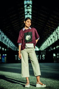 Woman wearing the Babette Trousers sewing pattern from Fibre Mood on The Fold Line. A trouser pattern made in stretch or non-stretch cotton twill, corduroy or leather(ette) fabrics, featuring a high waist, wide legs, zip fly, front and back pockets and cr