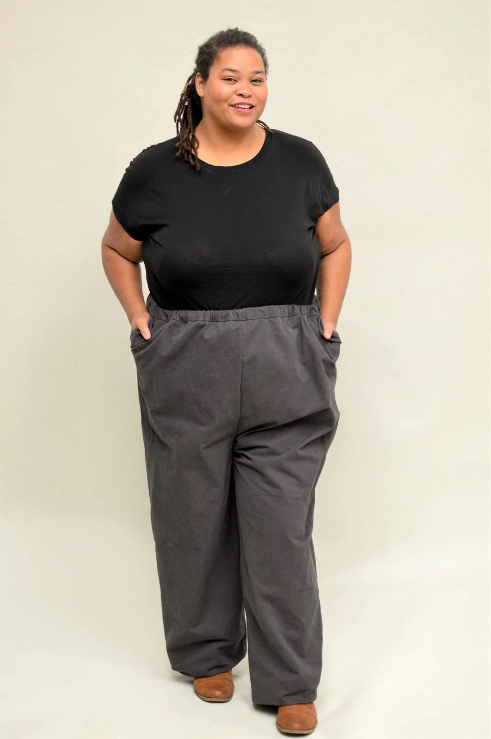 Woman wearing the Basics Pants sewing pattern from Folkwear on The Fold Line. A trouser pattern made in linen, flannel, gabardine, twill or lightweight denim fabrics, featuring an elastic-waist, relaxed fit, high-rise waist and front pockets with pocket f