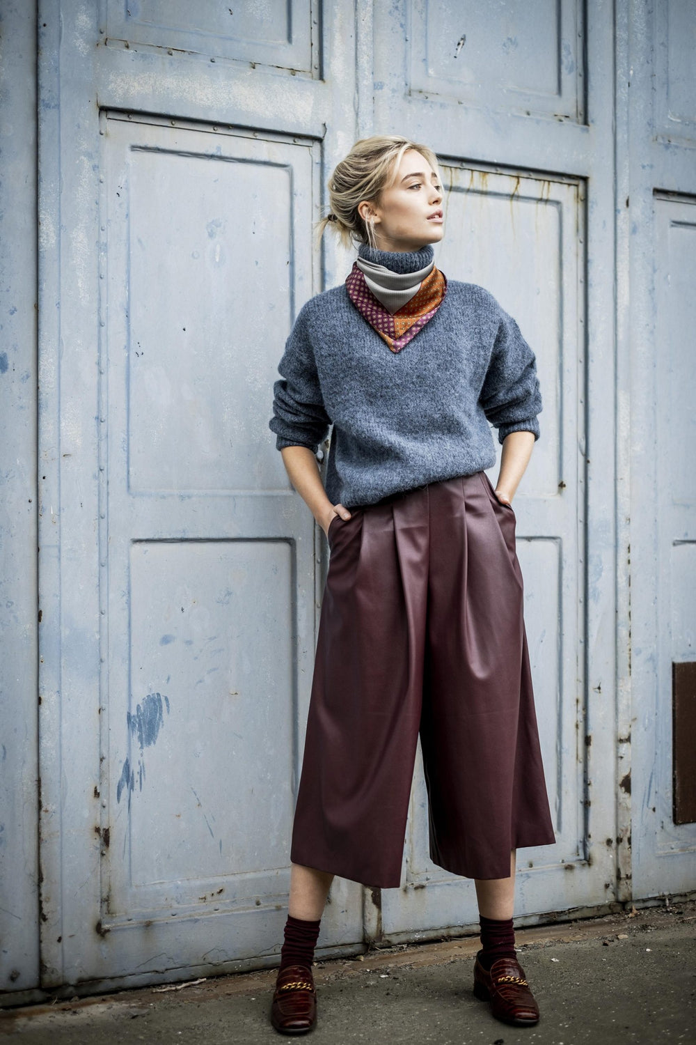 Woman wearing the Bea Culotte sewing pattern from Fibre Mood on The Fold Line. A culottes’ pattern made in (faux) leather, denim, cotton or corduroy fabrics, featuring wide-legs, buttons or snap waist closure, two front pleats at the front of each leg, ba