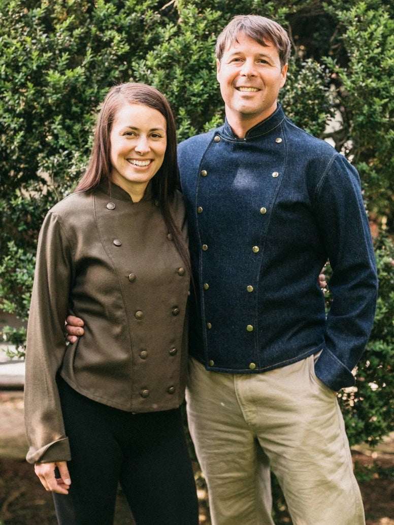 Man and Woman wearing the 133 Unisex Belgian Military Chef's Jacket sewing pattern from Folkwear on The Fold Line. A chefs jacket pattern made in poplin, denim, gabardine, corduroy, linen, light to medium-weight wool, or suiting weight silk fabrics, featu