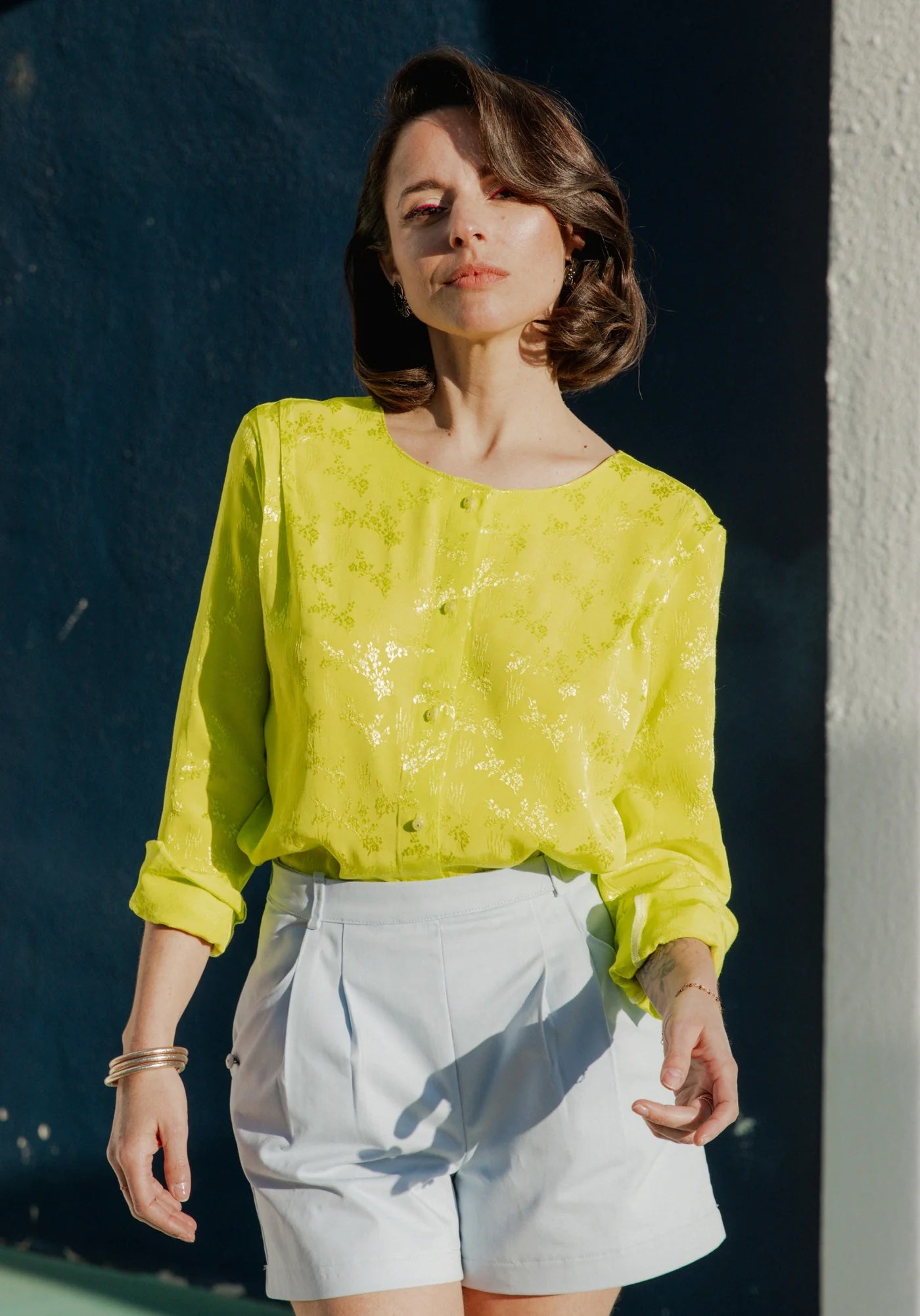 Woman wearing the Bellini Blouse sewing pattern from Maison Fauve on The Fold Line. A blouse pattern made in poplin, crepe, veil, lace, fine denim or chambray, cotton, viscose, linen, Tencel, or silk fabric, featuring a straight cut, pleats at the shoulde