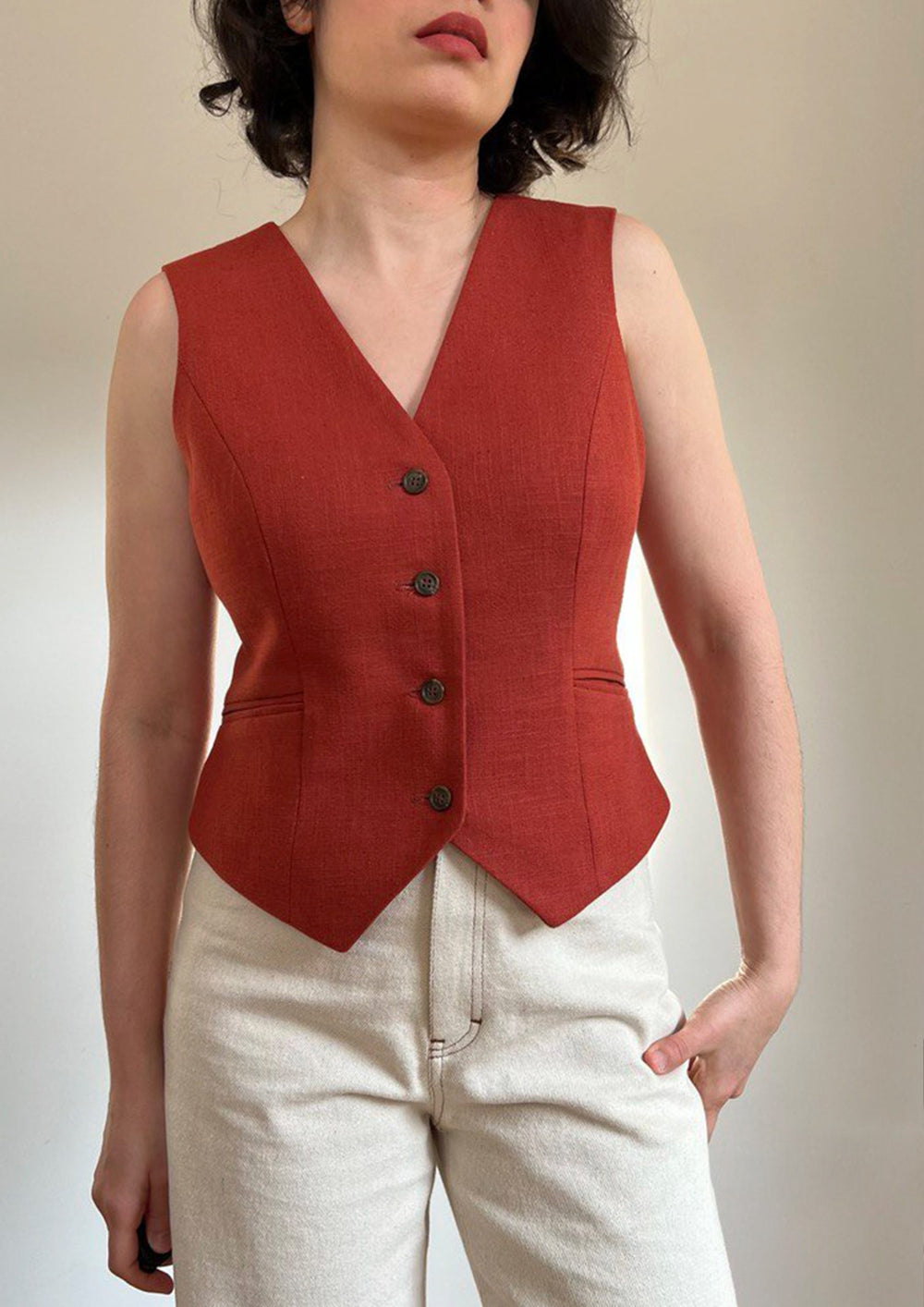 Woman wearing the Bennie Vest sewing pattern from Bella Loves Patterns on The Fold Line. A waistcoat pattern made in suitings, crepes, linen, twill, natural and synthetic suiting, and gabardine fabrics, featuring a V-shaped front neckline, side slanted do