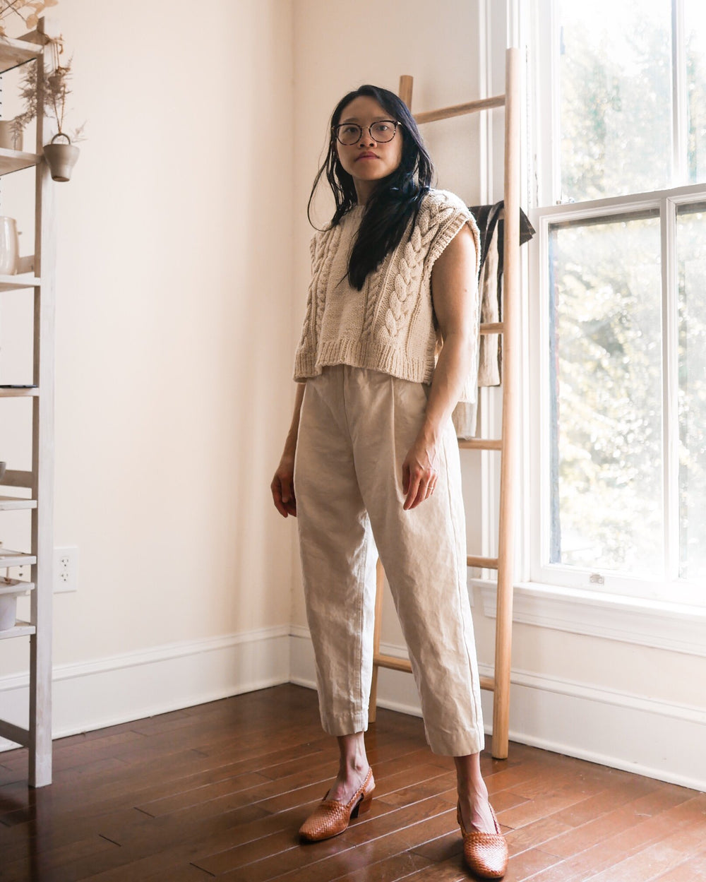 Woman wearing the Bisque Trousers sewing pattern from Vivian Shao Chen on The Fold Line. A trousers pattern made in cotton or linen fabric, featuring a high elasticated waist, slightly dropped crotch, deep front pleats, slant pockets, tapered leg, and cro