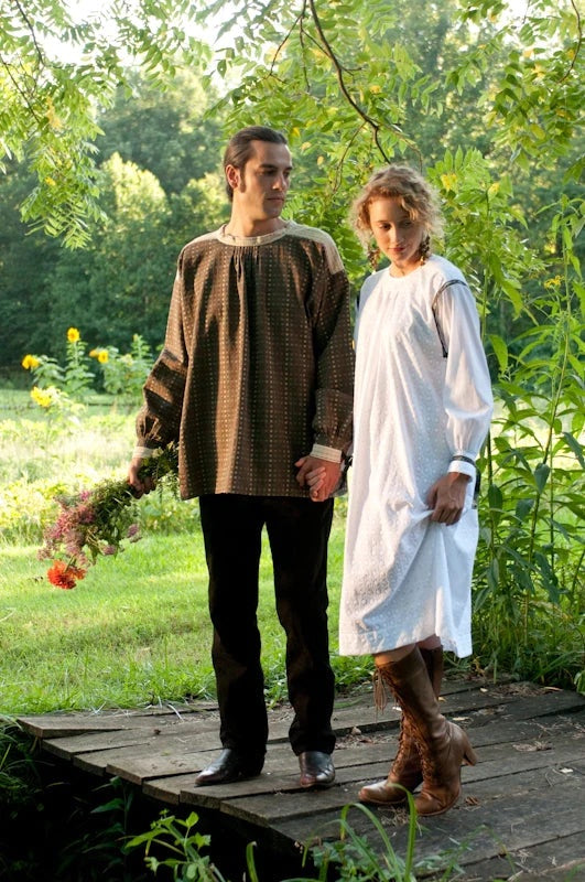 Man and Woman wearing the 148 Unisex Black Forest Smock sewing pattern from Folkwear on The Fold Line. A smock dress and top pattern made in linen, homespun, broadcloth, gingham, denim, featherweight corduroy or lightweight wool fabrics, featuring soft pl