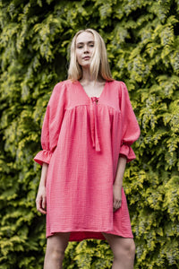 Woman wearing the Blossom Dress sewing pattern from Fibre Mood on The Fold Line. A dress pattern made in cotton voile, linen, double gauze, poplin, chambray, and seersucker fabrics, featuring an oversized silhouette, deep V-neckline with bow, front and ba