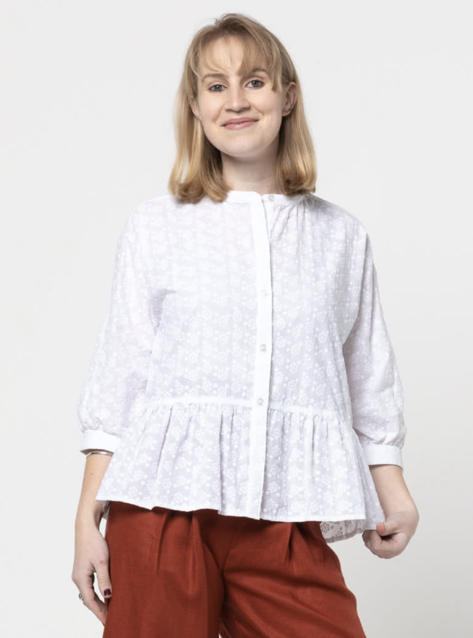Woman wearing the Blossom Woven Top sewing pattern from Style Arc on The Fold Line. A blouse pattern made in voile, silk, rayon or crepe fabrics, featuring a front button closure, front dolman sleeve and back set-in sleeve, gathered front neck and back yo