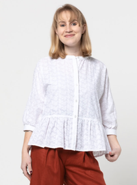 Woman wearing the Blossom Woven Top sewing pattern from Style Arc on The Fold Line. A blouse pattern made in voile, silk, rayon or crepe fabrics, featuring a front button closure, front dolman sleeve and back set-in sleeve, gathered front neck and back yo