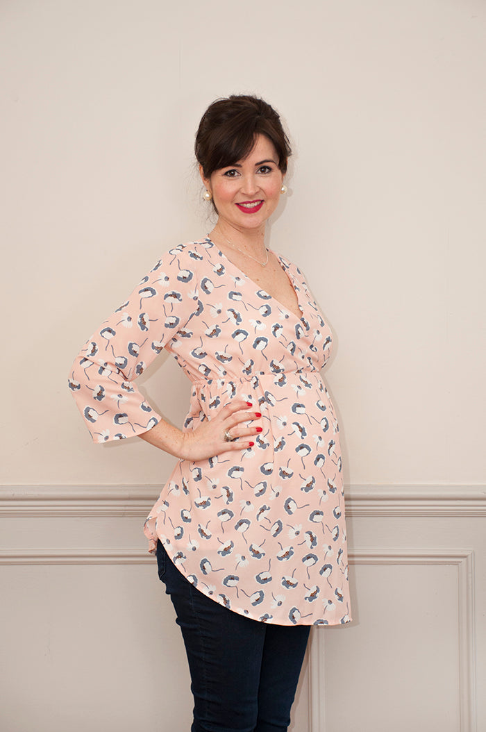Woman wearing the Blossom Maternity Top and Dress sewing pattern from Sew Over It on The Fold Line. A top or tunic pattern made in rayon, viscose or crepe fabrics, featuring a V-neck, faux wrap-style, nipped-in underbust, 3/4 length sleeves, and shaped he