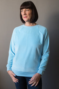 Woman wearing the Lynn Sweatshirt sewing pattern by Bobbins and Buttons. A sweatshirt pattern made in sweatshirt fabrics, stable knits, stretch velvet or lighter weight jersey fabrics, featuring a long raglan sleeve and rib trim on the neck, cuff and hem 