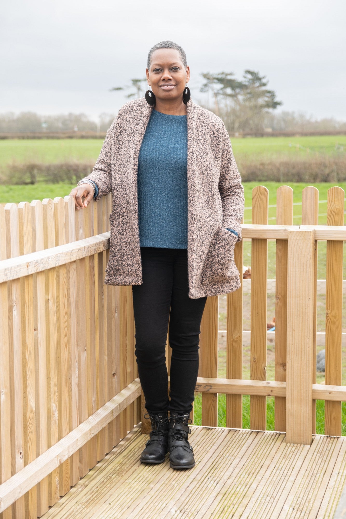 Woman wearing the Yvonne Coatigan sewing pattern by Bobbins and Buttons. A coatigan pattern made in stable knits such as ponte roma, jacquard knits or sweatshirt fabrics, featuring a relaxed fit with a raised back neck, pockets and long sleeves.