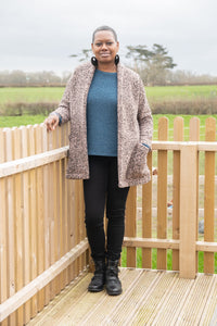 Woman wearing the Yvonne Coatigan sewing pattern by Bobbins and Buttons. A coatigan pattern made in stable knits such as ponte roma, jacquard knits or sweatshirt fabrics, featuring a relaxed fit with a raised back neck, pockets and long sleeves.