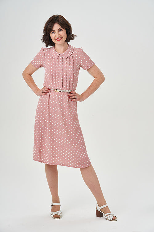 Woman wearing the Bonnie Dress sewing pattern from Sew Over It on The Fold Line. A dress pattern made in rayon, viscose, lightweight crepe, or silk fabric, featuring a feminine, 1940s-inspired silhouette, bodice with vertical pleats and a concealed button
