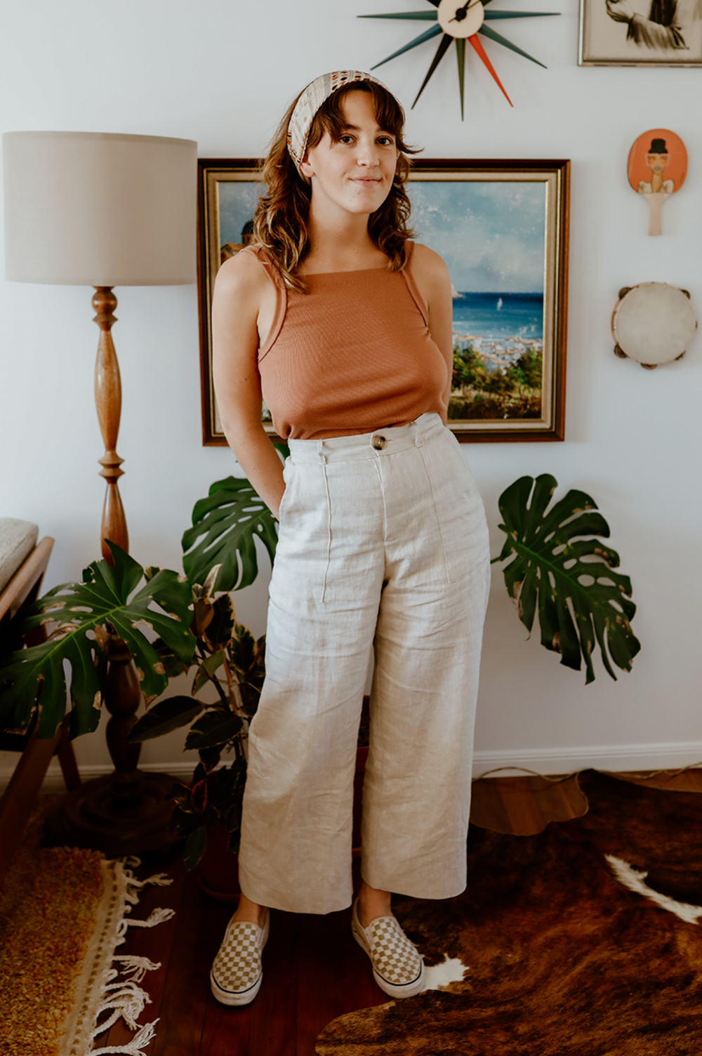 Woman wearing the Bottlebrush Pants sewing pattern from Common Stitch on The Fold Line. A trouser pattern made in linen fabrics, featuring full length flared legs, high waist, fly-front zip closure and top button, belt loops, pockets, front patch pockets 