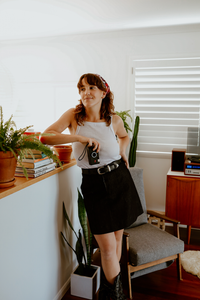 Woman wearing the Bottlebrush Skirts sewing pattern from Common Stitch on The Fold Line. An A-line skirt pattern made in denim, corduroy, heavyweight cotton, twill, gabardine or linen fabrics, featuring a high waist, fly-front zip closure and top button, 