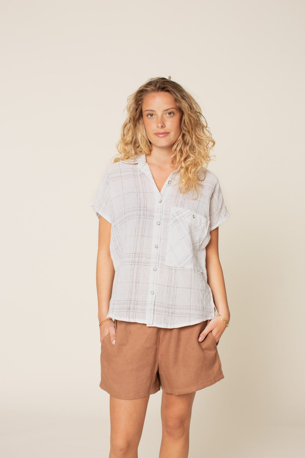Woman wearing the Boxy Shirt sewing pattern from Wardrobe by Me on The Fold Line. A shirt pattern made in cotton voile, linen, poplin, or chambray fabrics, featuring a boxy fit, grown-on dropped shoulders, side seam and shoulder seam slits, collar and sta