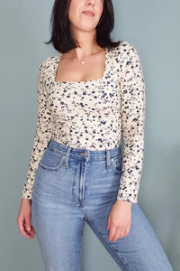 Woman wearing the Brigit Tee sewing pattern from Pattern Scout on The Fold Line. A Tee Shirt pattern made in Jersey, rib knit, cotton/spandex blends, and brushed poly/spandex knit fabrics, featuring a fitted silhouette, plunging square neckline, long slee