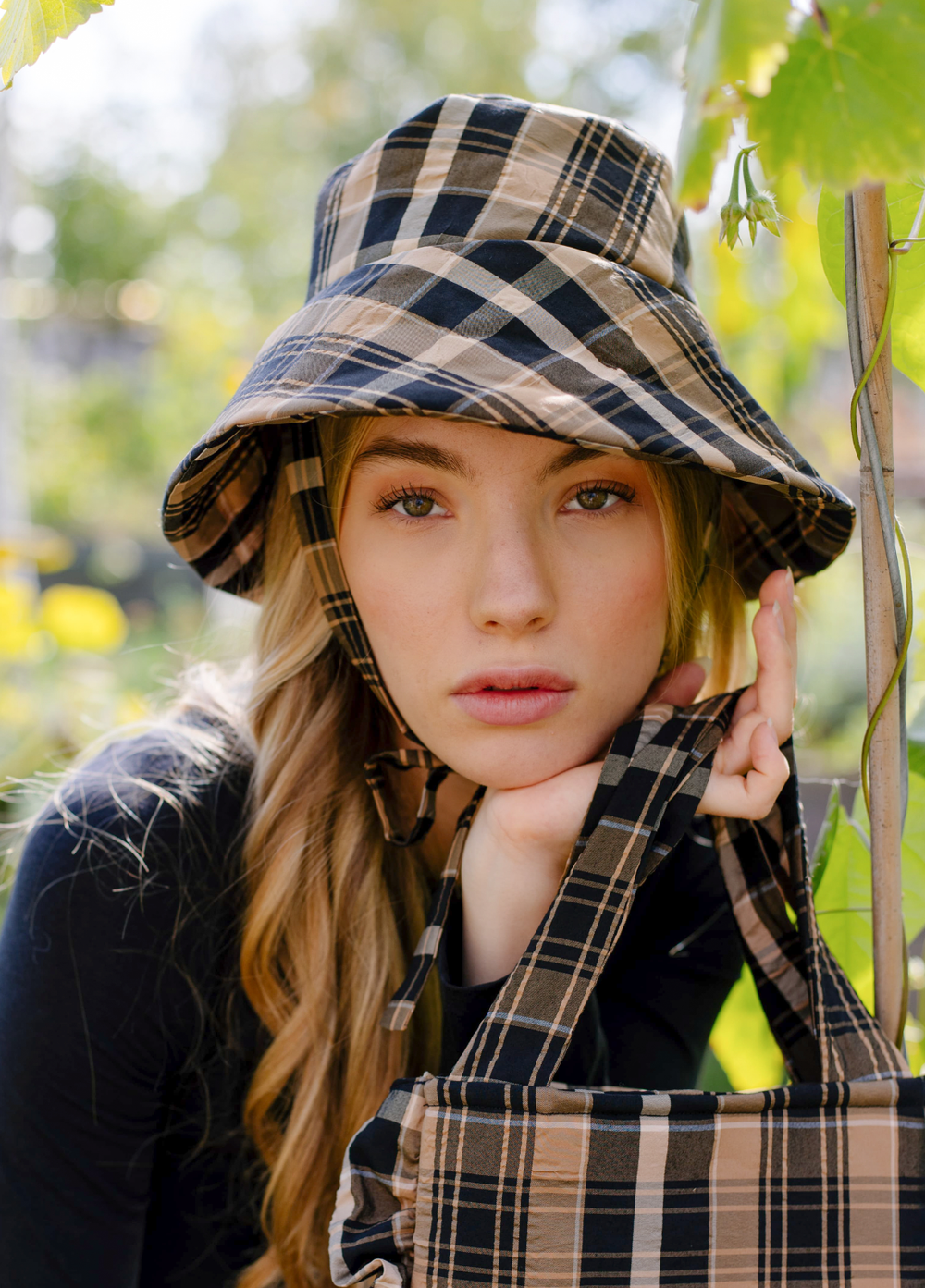 Woman wearing the Bucket Hat sewing pattern from JULIANA MARTEJEVS on The Fold Line. A unisex hat pattern made in cotton denim fabrics, featuring an under chin fabric tie, three sizes, and broad rim.