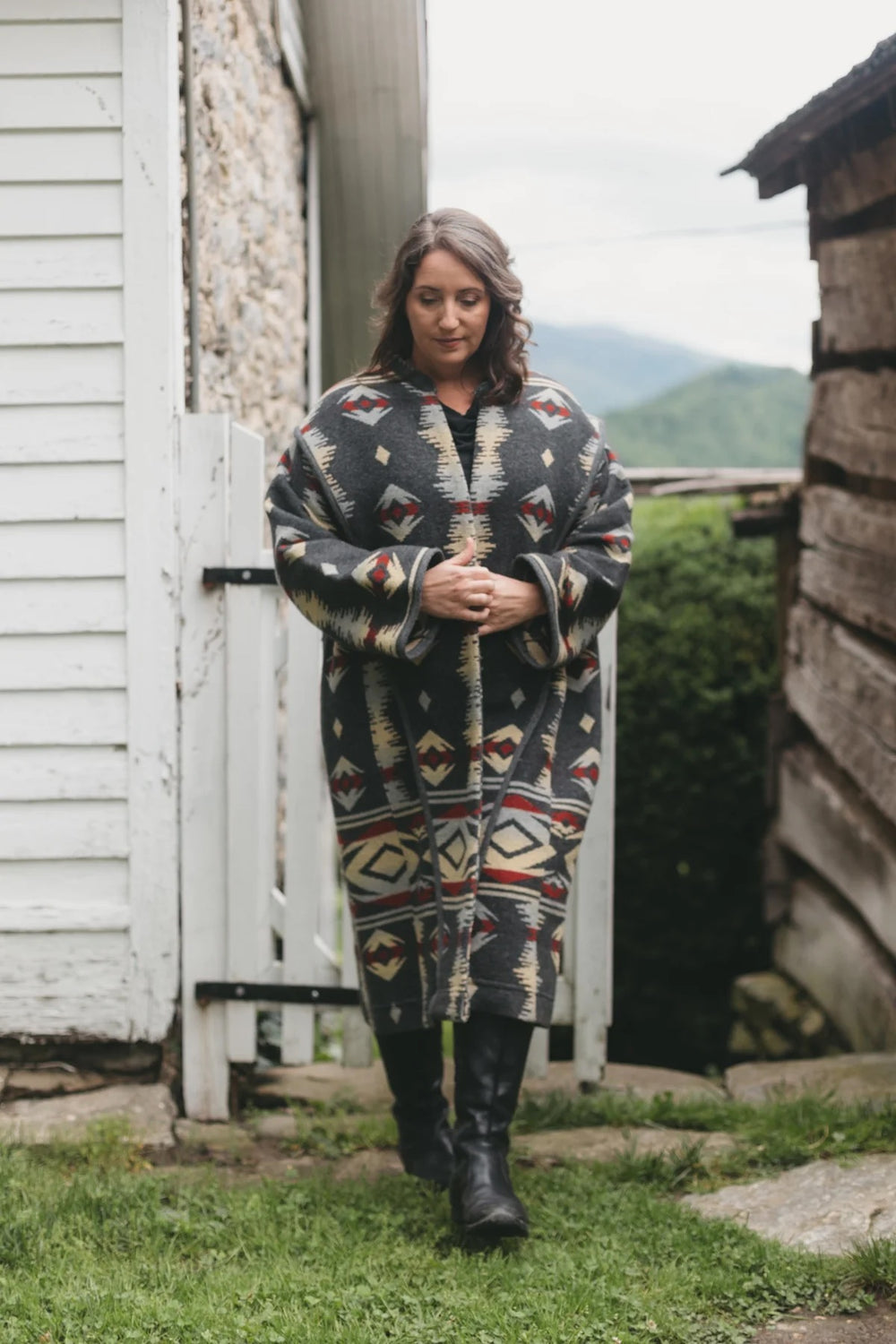 Woman wearing the 150 Unisex Hungarian Szur sewing pattern from Folkwear on The Fold Line. A coat pattern made in wool, corduroy, or denim fabric, featuring a dramatic oversized silhouette, lined lapel and collar back, long sleeves, and mid-calf length.