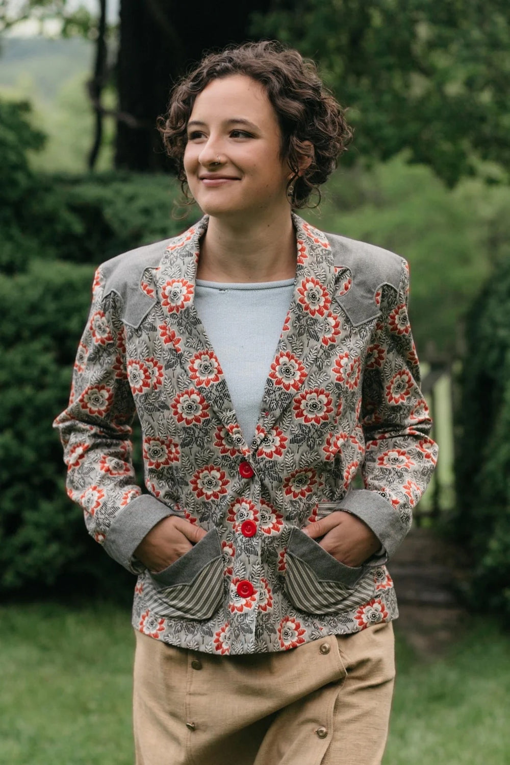 Woman wearing the 242 Rodeo Cowgirl Jacket sewing pattern from Folkwear on The Fold Line. A jacket pattern made in denim, cotton, suede, leather, velvet, or medium to heavyweight silk fabric, featuring princess seams, a shawl collar, long set-in sleeves, and decorative shoulder yokes, cuffs, and pockets.