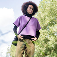 Woman wearing the Abina Top sewing pattern from Fibre Mood on The Fold Line. A top pattern made in rib jersey, French terry, scuba, interlock, or knitted jacquard fabric, featuring a loose fit, round neckline, and short raglan sleeves.