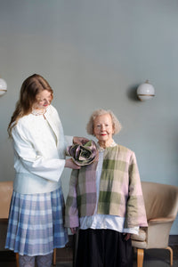 Woman wearing the Adele Boutonnière sewing pattern from TAUKO on The Fold Line. An accessory pattern made in cotton or linen fabric, featuring an oversized rose shape.