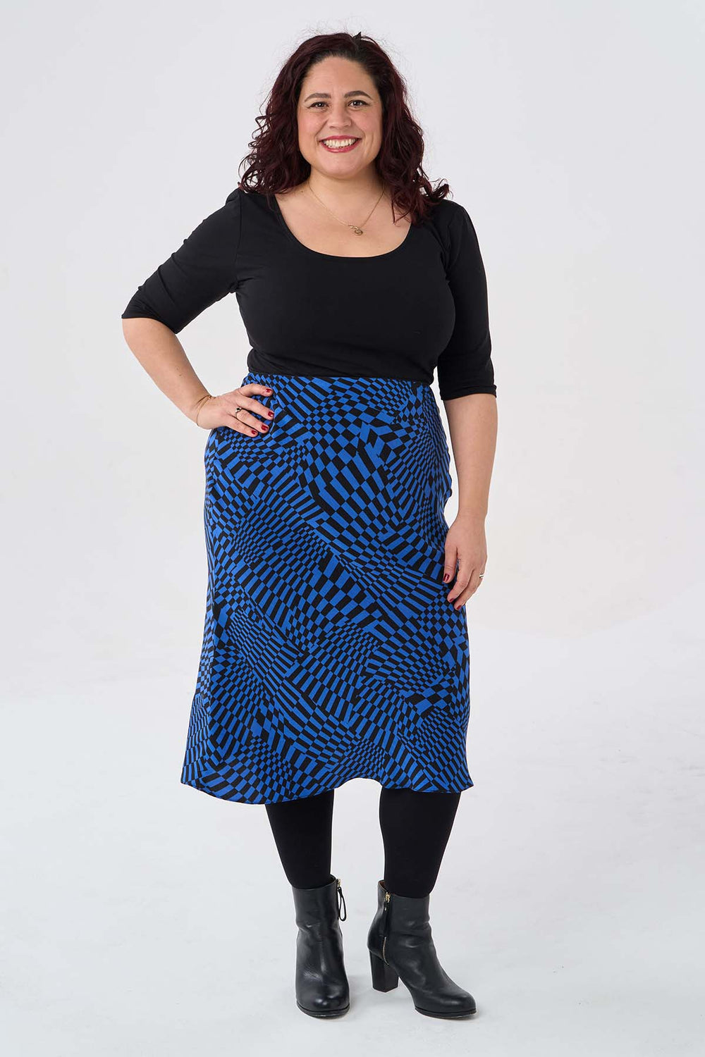 Woman wearing the Adelle Top sewing pattern from Sew Over It on The Fold Line. A top pattern made in knit fabric, featuring a fitted silhouette, ballet-style scooped neckline at the front and back, and elbow-length sleeves.