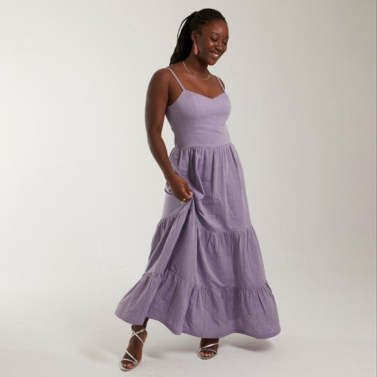 Woman wearing the Adriana Dress sewing pattern from Coralie Bijasson on The Fold Line. A sundress pattern made in cotton, double gauze, crepe, linen, or viscose fabric, featuring thin straps, princess seams, a shirred back panel, tiered skirt, and maxi length.