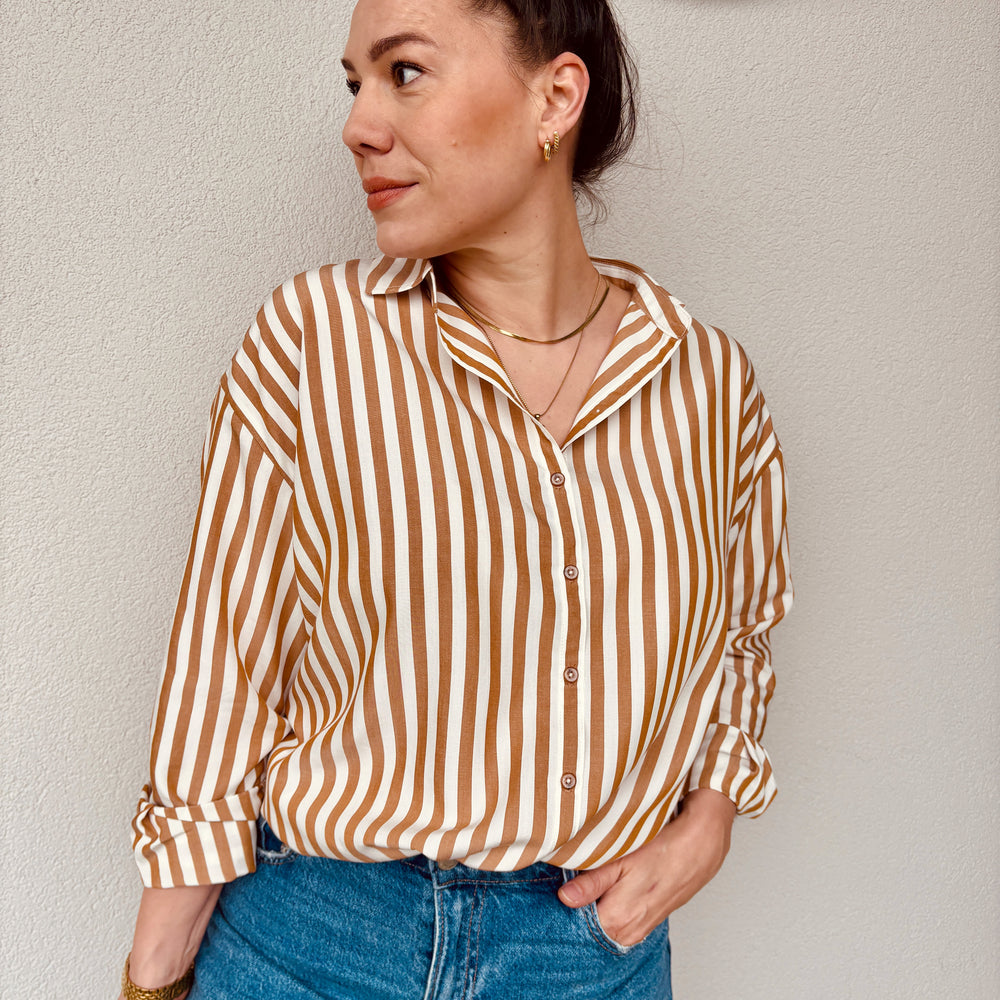 Woman wearing the Alea Shirt sewing pattern from Sew.lala Patterns on The Fold Line. A shirt pattern made in linen, poplin, viscose, tencel, or silk fabric, featuring a relaxed fit, collar, dropped shoulders, button front, and long sleeves.