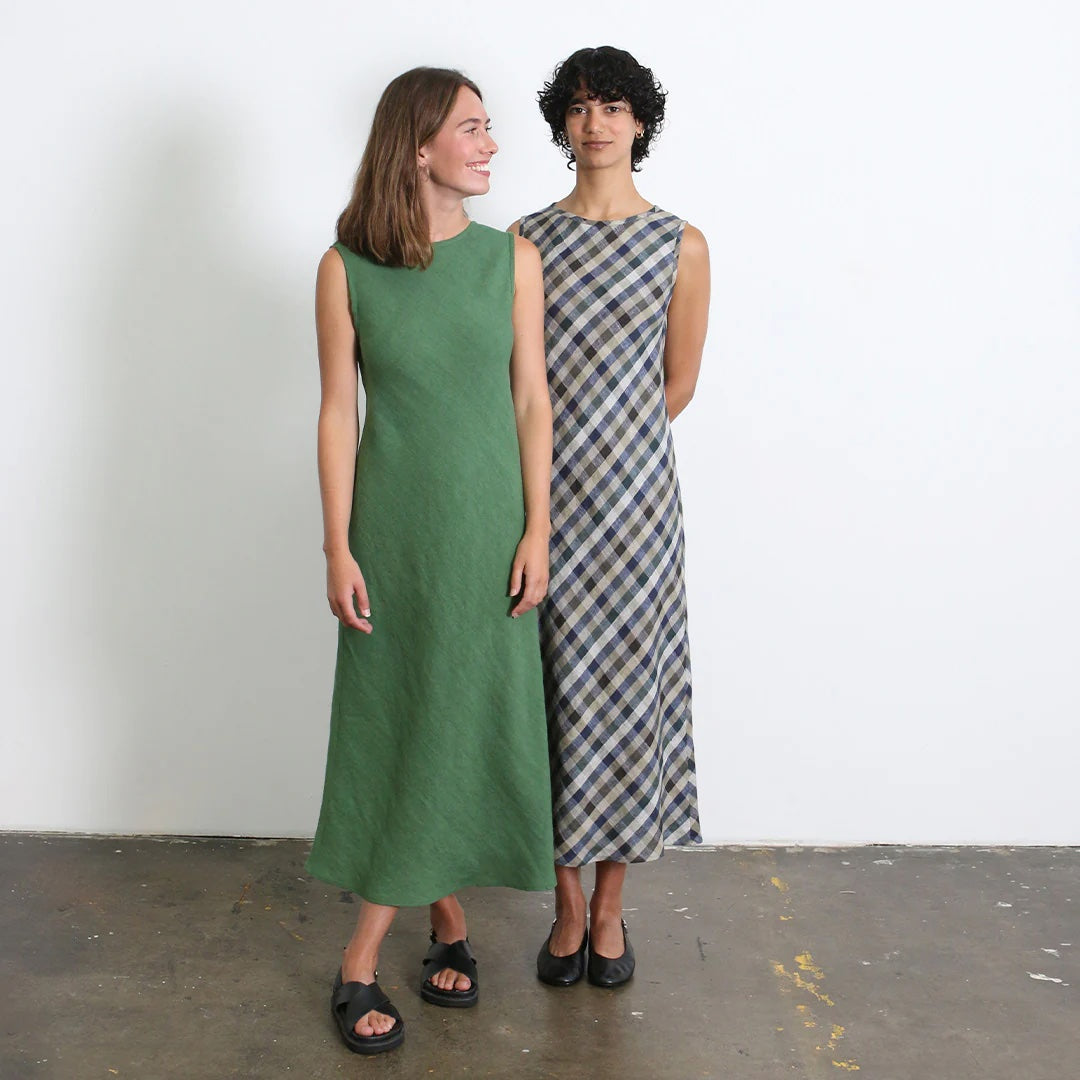 Women wearing the Alessi Bias Dress sewing pattern from Tessuti Fabrics on The Fold Line. A sleeveless bias cut dress pattern made in linen, linen blend, silk satin, silk crepe de chine, viscose crepe, or wool crepe fabric, featuring a round neckline, self-binding at the neckline and armholes, narrow hem, and midi length.