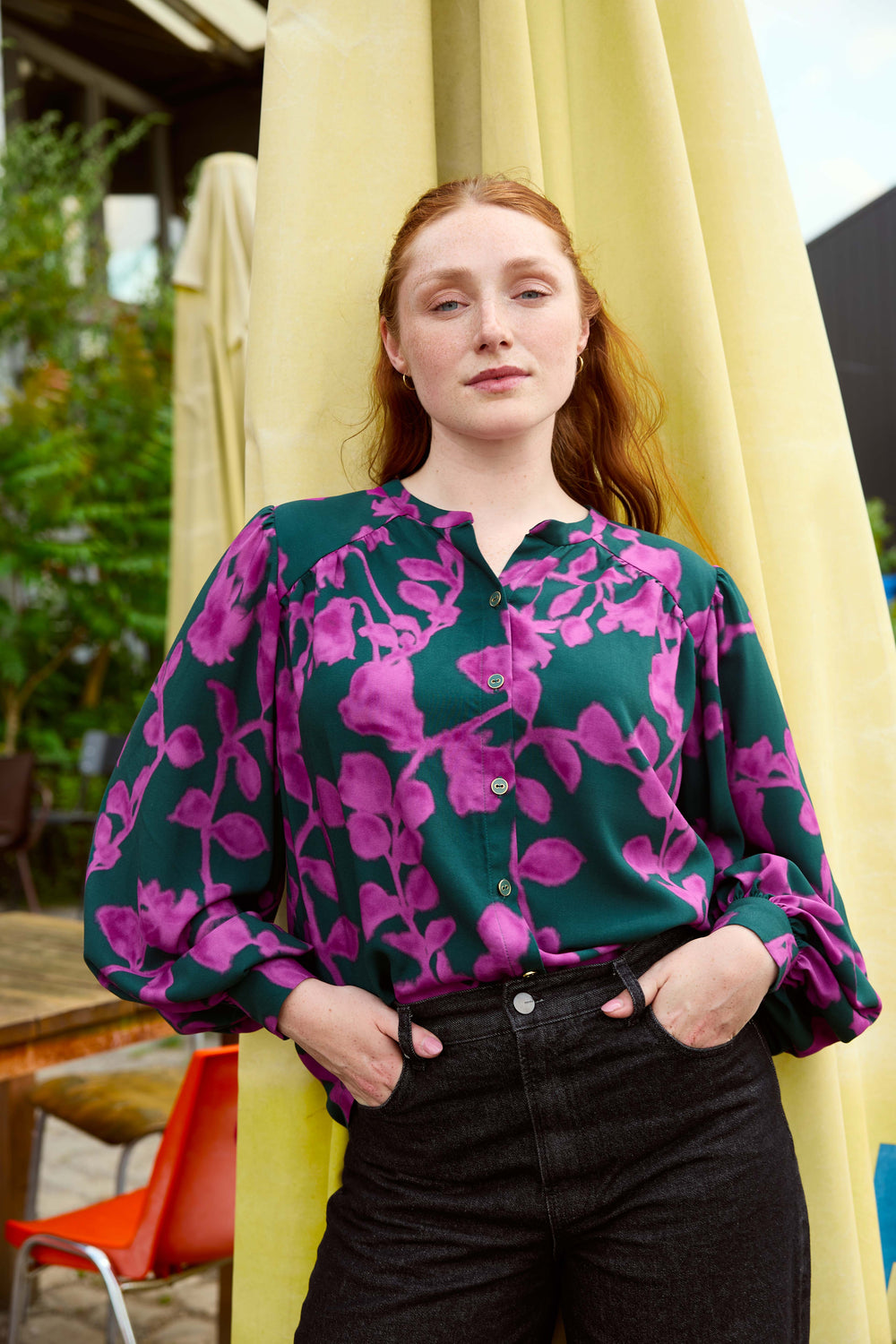 Woman wearing the Alexa Blouse sewing pattern from Atelier Jupe on The Fold Line. A top pattern made in viscose, cotton, tencel, double gauze, or linen fabric, featuring an oversized silhouette, shoulder gathers, button placket, and voluminous statement sleeves with cuffs.
